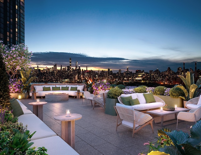 patio terrace at dusk with an outdoor living space with a fire pit