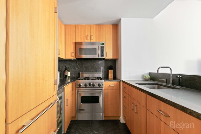 100 W 58th St Unit 2-A, New York City, NY 10019 - kitchen featuring stainless steel appliances, decorative backsplash, dark stone counters, marble finish floor, and a sink