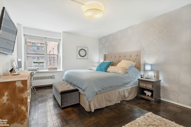 bedroom with wallpapered walls, baseboards, radiator heating unit, an accent wall, and cooling unit