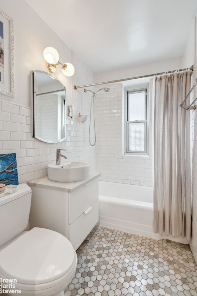 bathroom with toilet, shower / bath combination with curtain, tile walls, and vanity