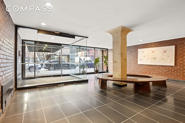 88 Bleecker St Unit 2A, New York City, NY 10012 - building lobby featuring expansive windows, brick wall, and recessed lighting