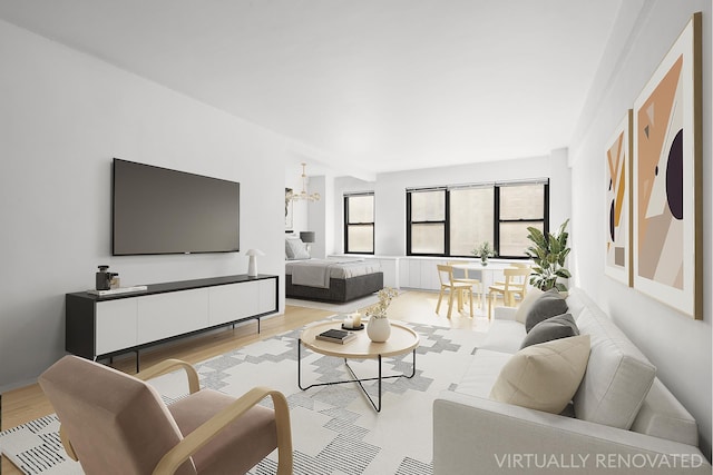 living room with light wood-style floors and a chandelier