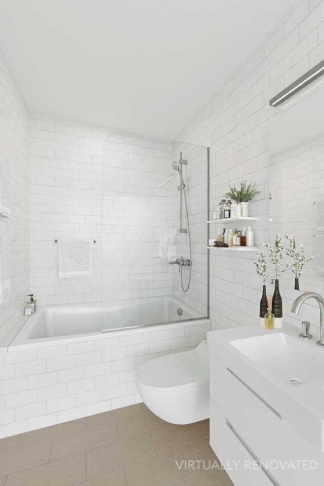 full bathroom with toilet, tile patterned floors, tiled shower / bath, vanity, and tile walls