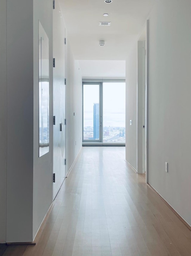 hallway with visible vents and light wood-style flooring