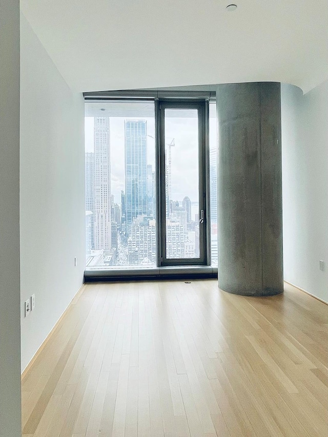 empty room with wood finished floors and a city view