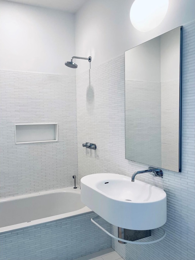 full bath featuring tiled shower / bath and tile walls