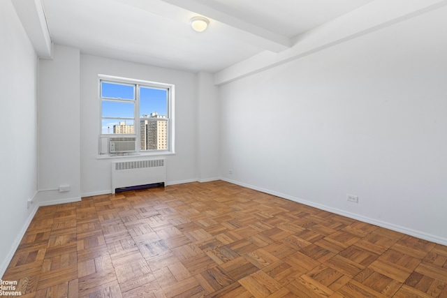 unfurnished room featuring baseboards and radiator heating unit