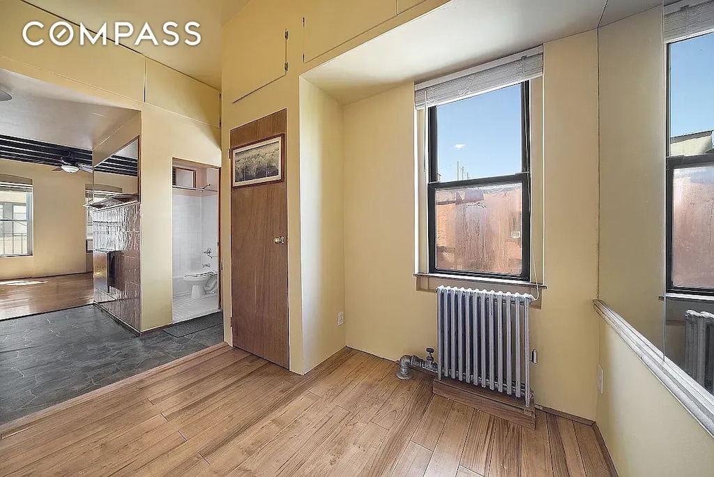 empty room featuring radiator and wood finished floors