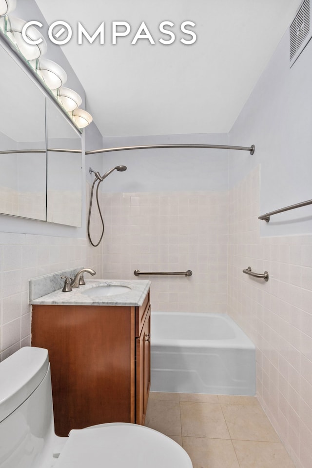 bathroom featuring visible vents, toilet, tile patterned flooring, tile walls, and shower / bathing tub combination