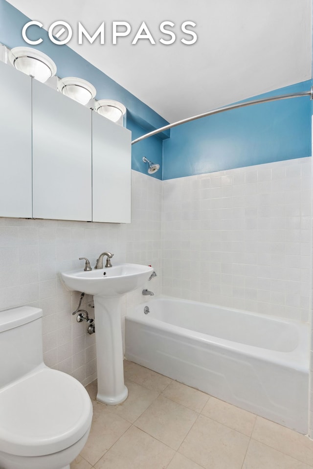 full bath featuring tile walls, bathtub / shower combination, toilet, and tile patterned floors