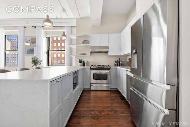 kitchen featuring stainless steel appliances, light countertops, beam ceiling, and under cabinet range hood