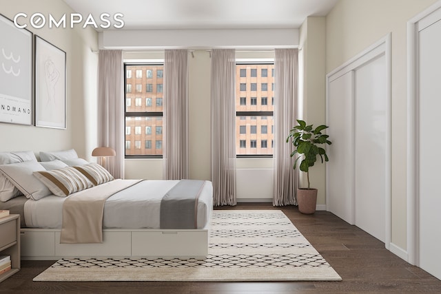 bedroom with dark wood-style flooring and multiple windows