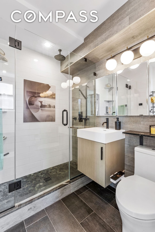 full bathroom with vanity, a stall shower, tile patterned flooring, toilet, and backsplash