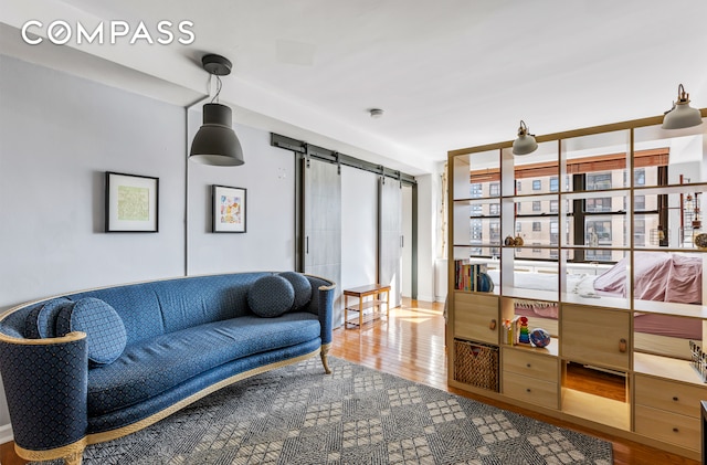 living area featuring a barn door and wood finished floors