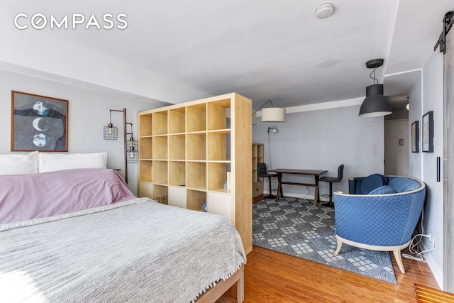 bedroom with baseboards and wood finished floors