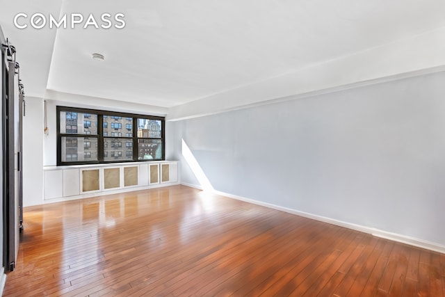 empty room featuring baseboards and hardwood / wood-style floors