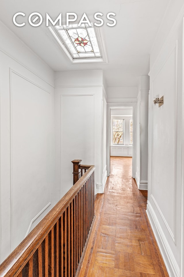 corridor with a decorative wall and an upstairs landing