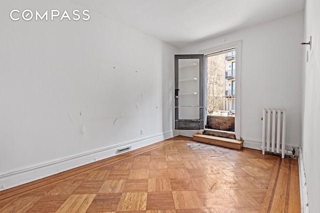 interior space with visible vents, baseboards, and radiator