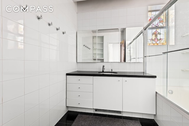 bathroom with vanity, tile walls, and tiled shower / bath combo