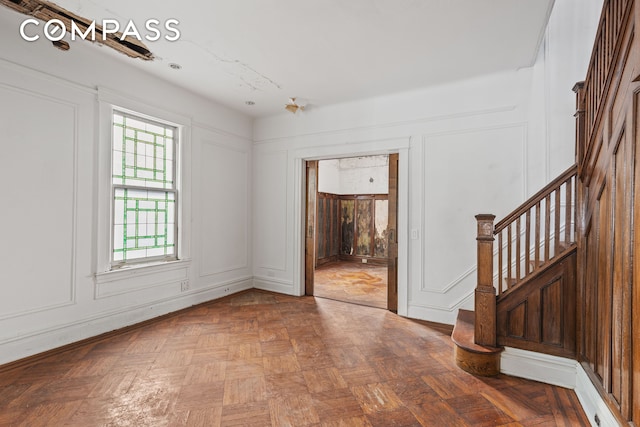 empty room featuring stairs and a decorative wall