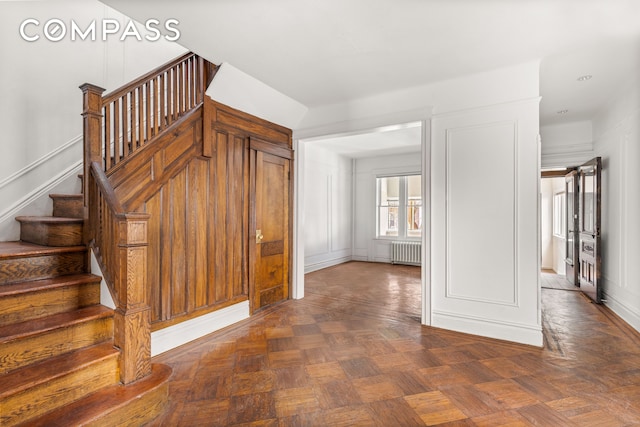 stairs with radiator and a decorative wall