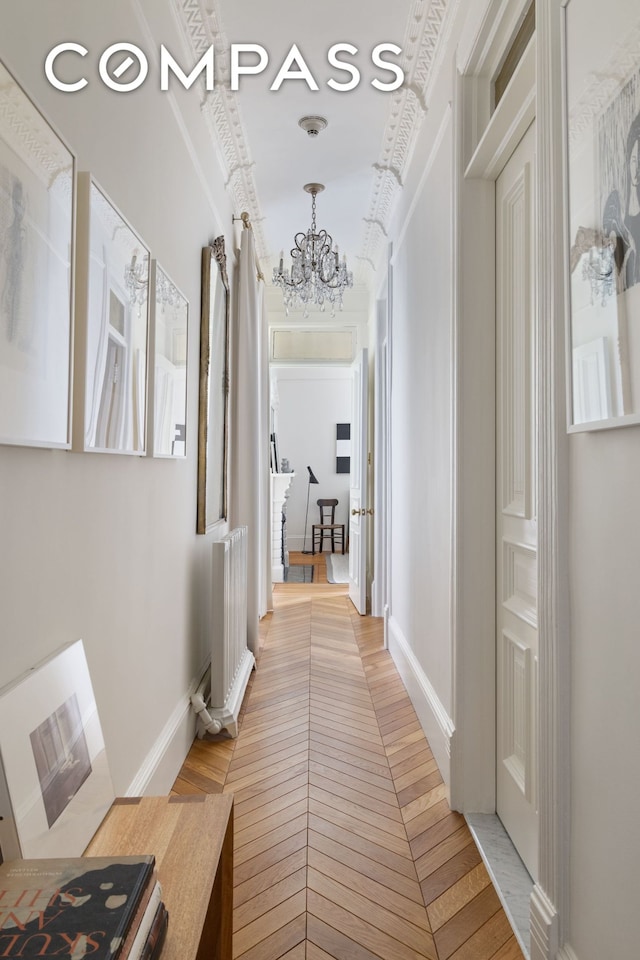 corridor featuring a notable chandelier and baseboards