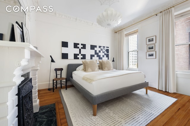 bedroom featuring a fireplace and wood finished floors