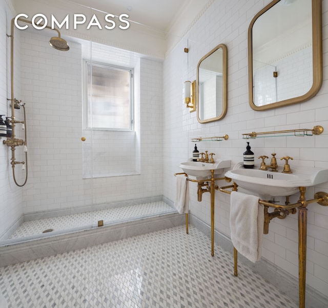 bathroom featuring crown molding, tile walls, decorative backsplash, a stall shower, and a sink