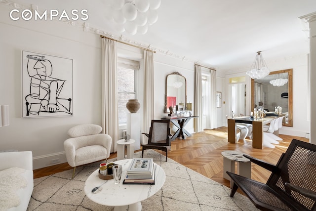 sitting room with baseboards and an inviting chandelier