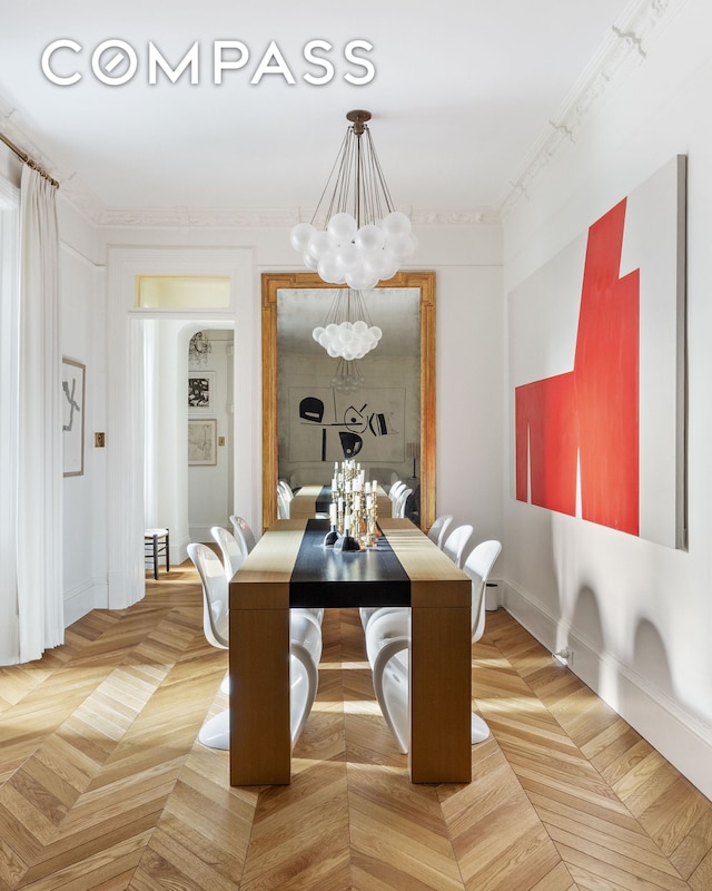 dining area featuring crown molding, baseboards, and a notable chandelier