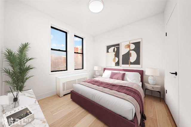 bedroom with baseboards, radiator, and light wood-style floors