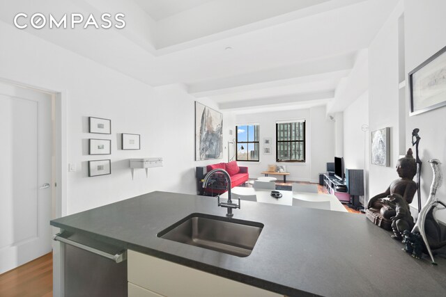 1 Hanson Pl Unit 15M, New York City, NY 11243 - kitchen with open floor plan, dark countertops, a desk, wood finished floors, and white cabinetry