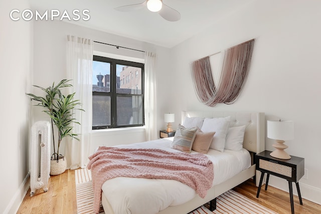 bedroom featuring a ceiling fan, baseboards, and wood finished floors