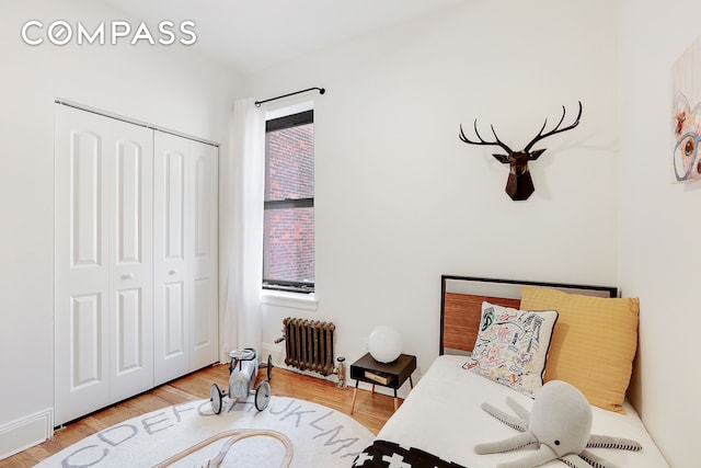 living area featuring radiator, a healthy amount of sunlight, and wood finished floors