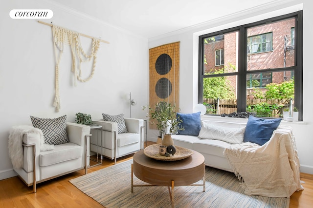 sitting room with visible vents, crown molding, baseboards, and wood finished floors