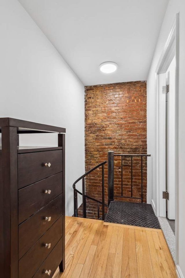 hall with an upstairs landing and wood finished floors