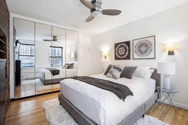 bedroom featuring wood finished floors, a closet, a ceiling fan, and baseboards