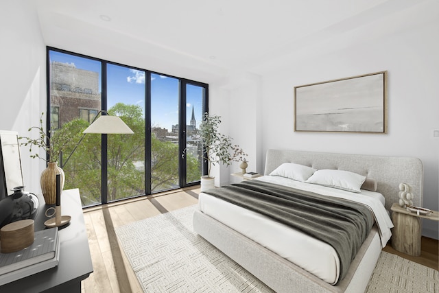 bedroom with wood finished floors and floor to ceiling windows