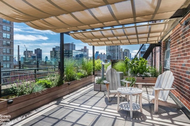 view of patio / terrace with a balcony, a view of city, and a pergola