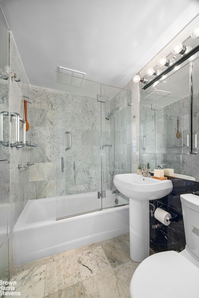 full bathroom with toilet, combined bath / shower with glass door, and tile walls