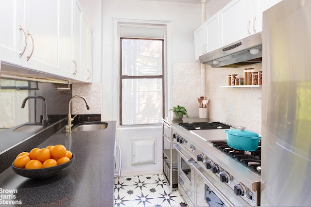 kitchen with under cabinet range hood, tasteful backsplash, white cabinets, and a sink