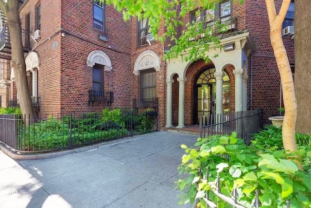 entrance to property featuring brick siding and fence