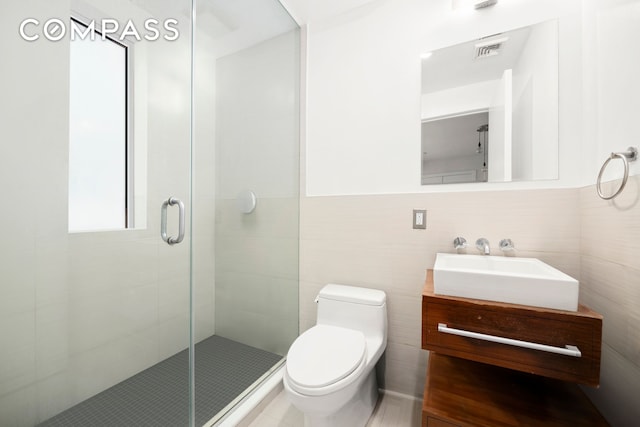 bathroom featuring visible vents, toilet, a stall shower, and vanity