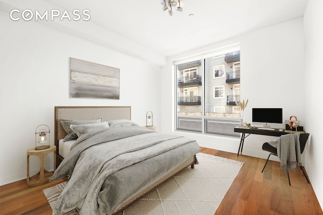 bedroom with baseboards and wood finished floors