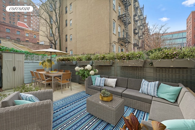 view of patio / terrace with outdoor dining area, fence, and an outdoor hangout area