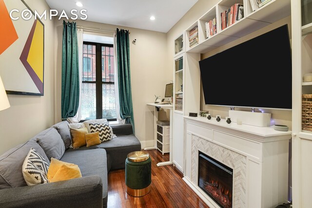 living area with recessed lighting, baseboards, and dark wood-type flooring