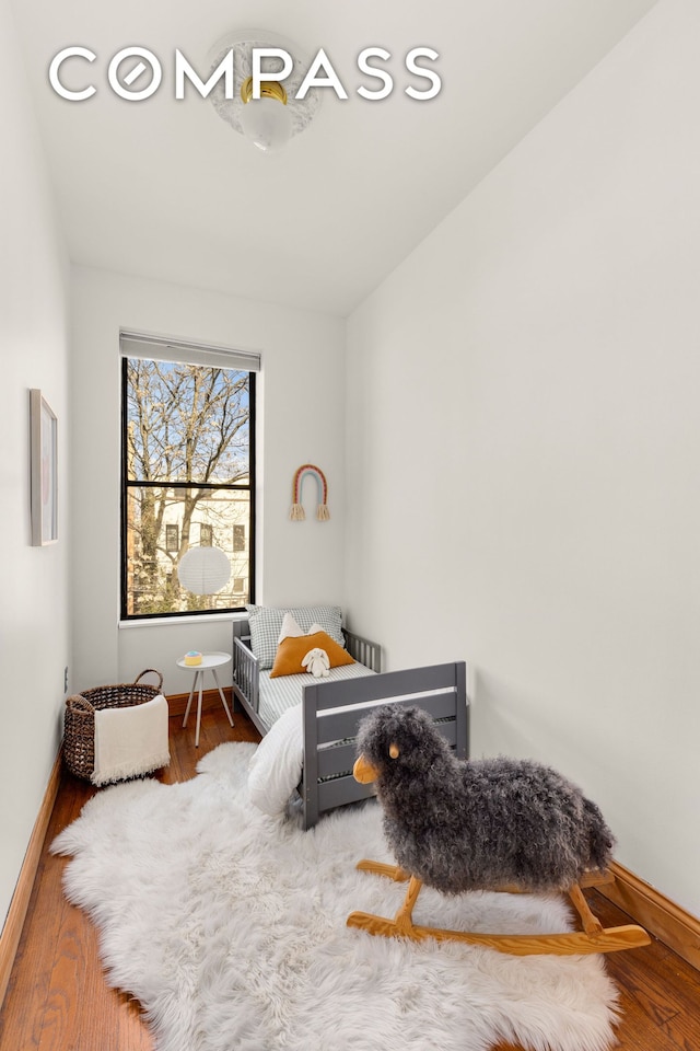 bedroom featuring baseboards and wood finished floors