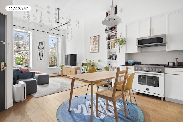 dining room with visible vents, light wood-style flooring, and baseboard heating