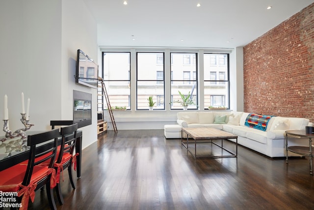 living room with brick wall, recessed lighting, and wood finished floors