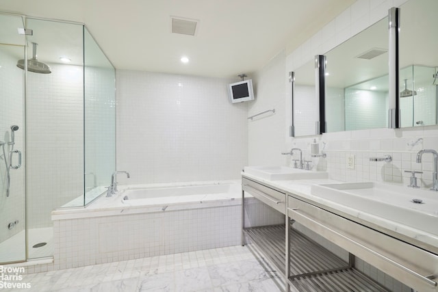 full bath featuring a bath, tile walls, a sink, and a stall shower
